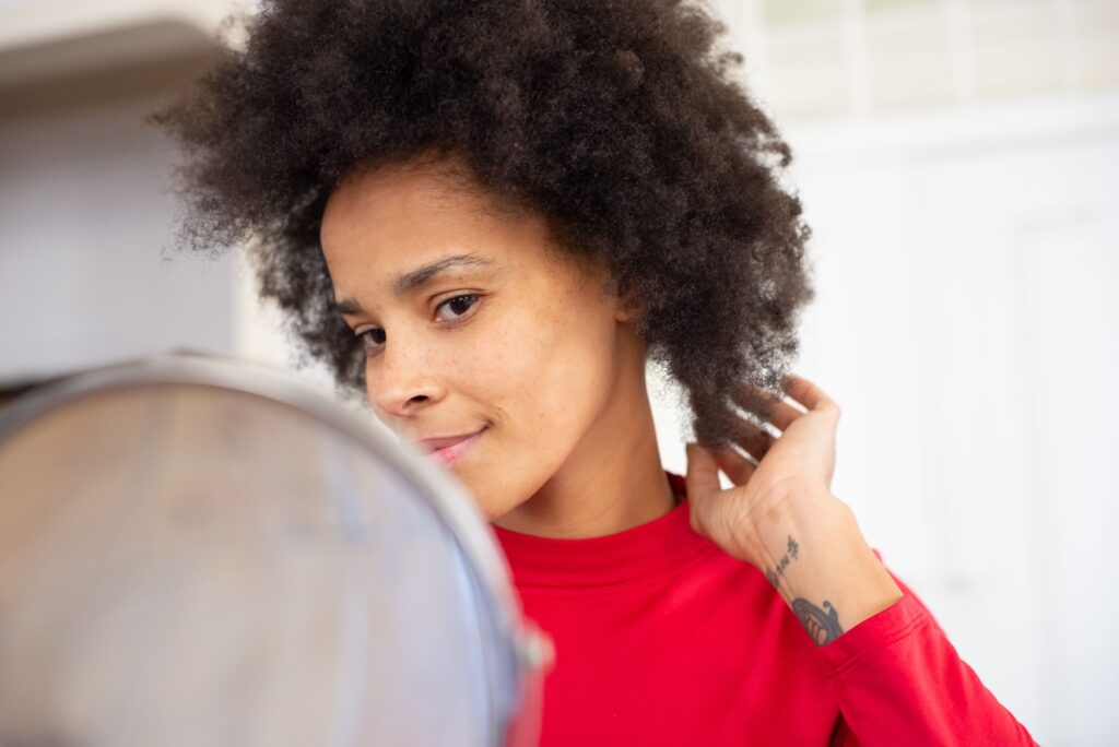 Woman examining her natural 4C hair texture