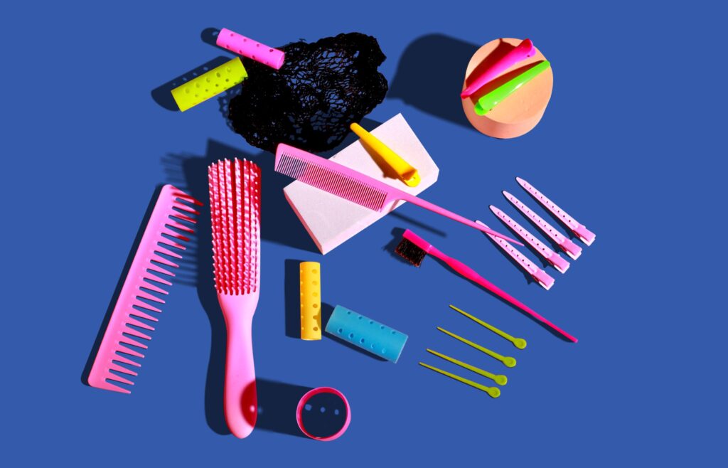 Freshly washed combs, brushes, and hair clips drying on a clean towel.