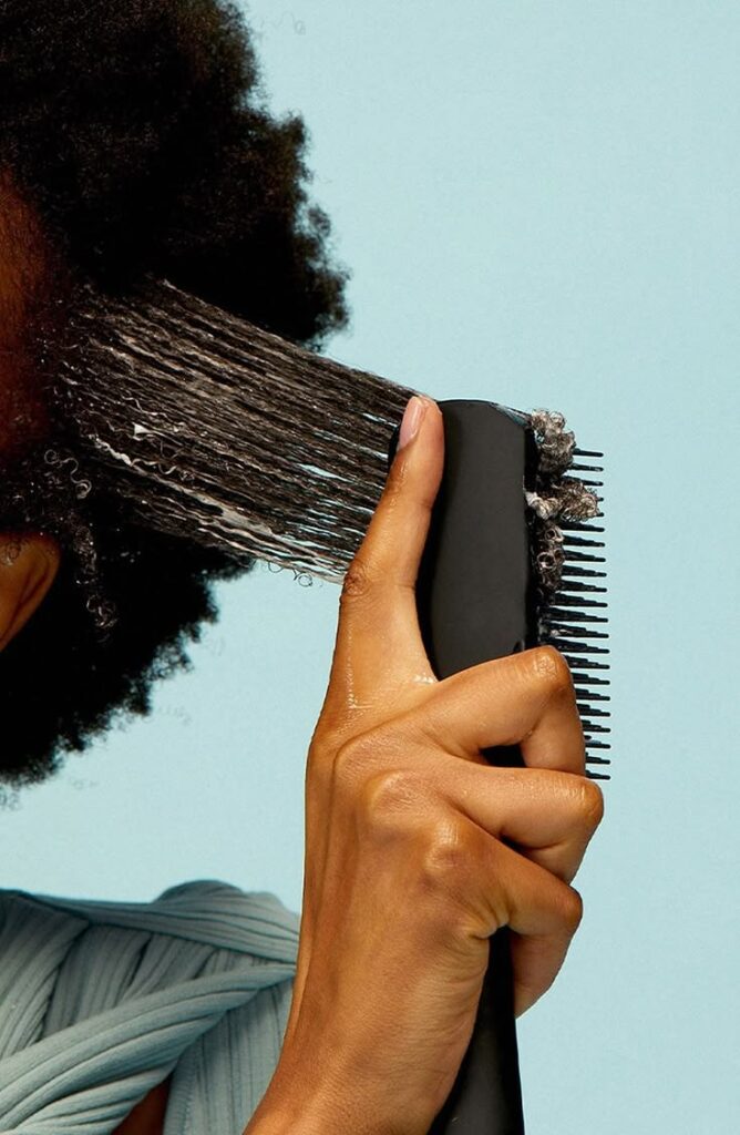 Person gently detangling natural 4C hair to reduce breakage