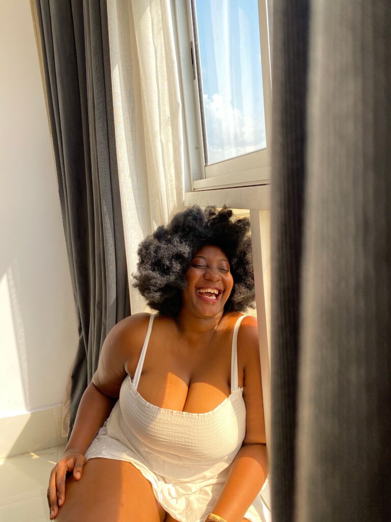 Woman smiling confidently with her healthy natural 4C hair.