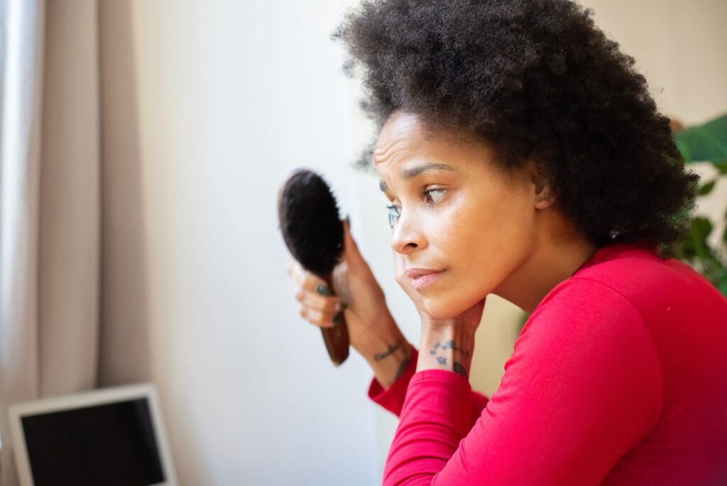 Woman maintaining healthy natural 4C hair with a simple daily routine