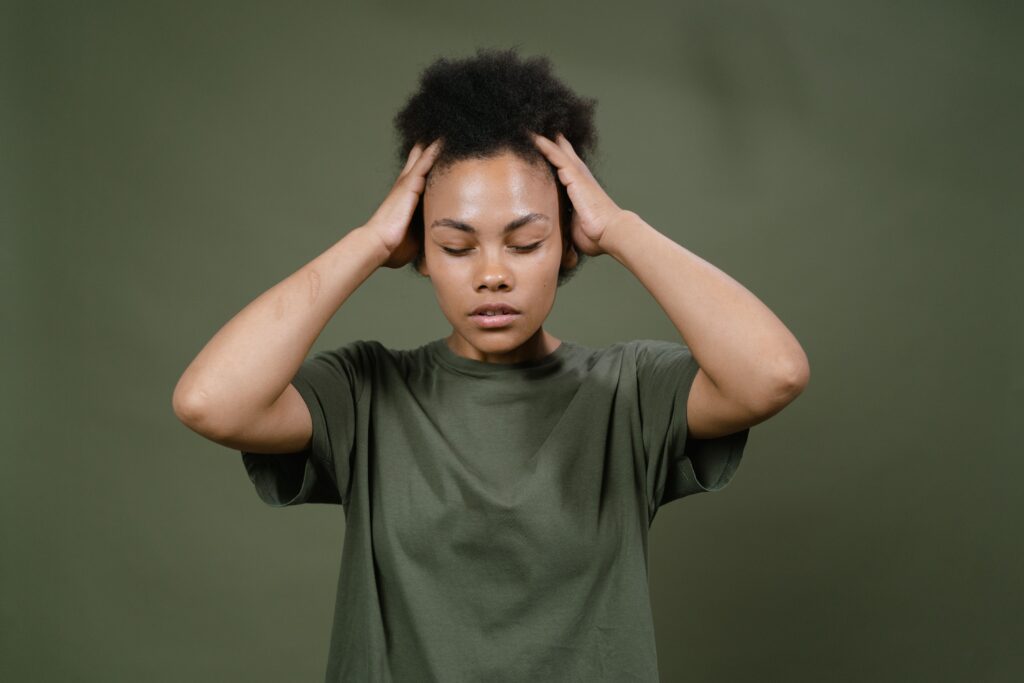 Black woman gently scratching her scalp before wash day.