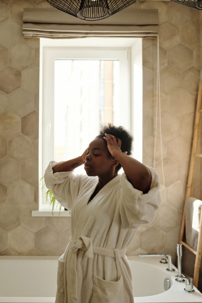 Woman gently massaging her scalp during a monthly natural hair routine.