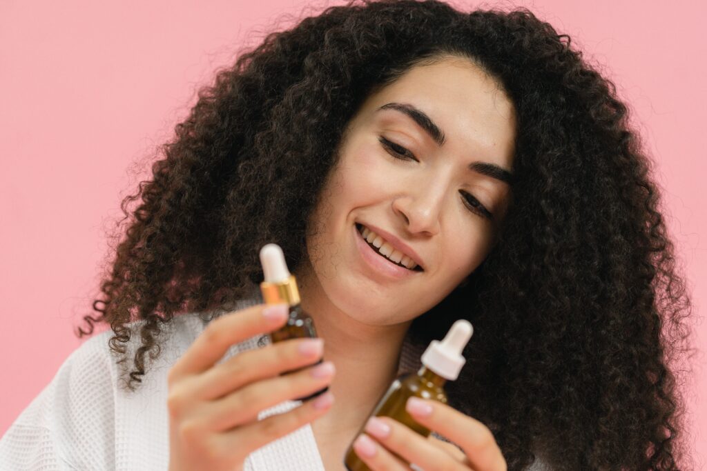 Black woman comparing natural hair products during her monthly hair care routine.