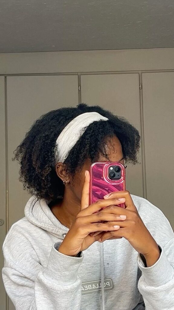 Braid-out with a headband on natural 4C hair.