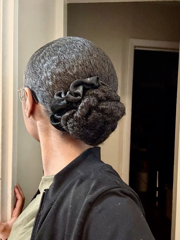Low braided bun on healthy natural 4C hair.
