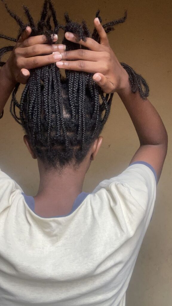 Woman checking new growth in her protective hairstyle.