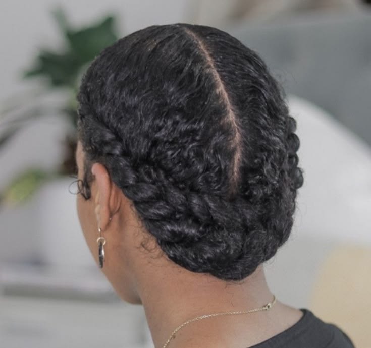 Black woman styling her freshly washed 4C hair at home.
