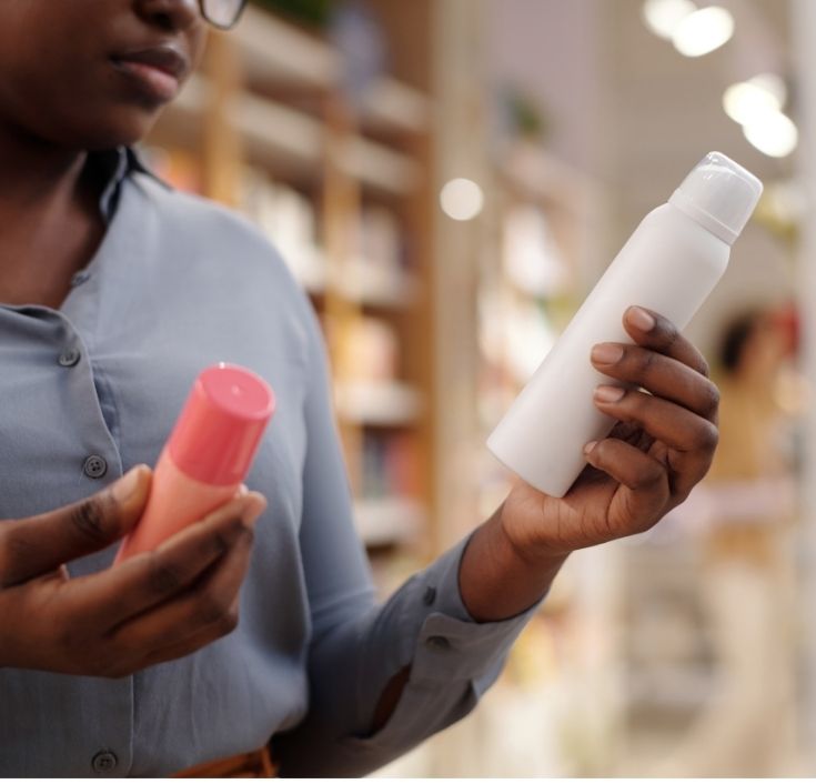 Woman reading the ingredients on a shampoo bottle for natural 4C hair.