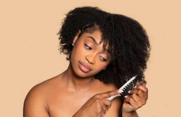 Woman following a consistent weekly routine for healthy natural 4C hair.
