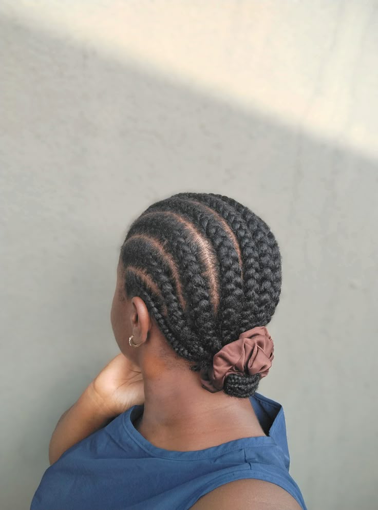 Black woman wearing neat cornrows to protect healthy 4C hair.