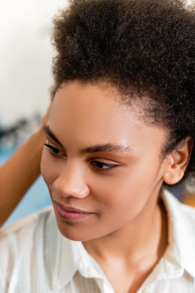 Woman smiling after washing her natural hair and scalp.