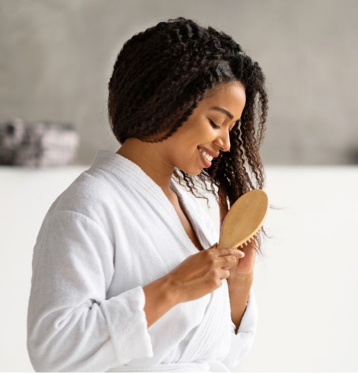 Black woman caring for healthy natural 4C hair during her weekly routine.
