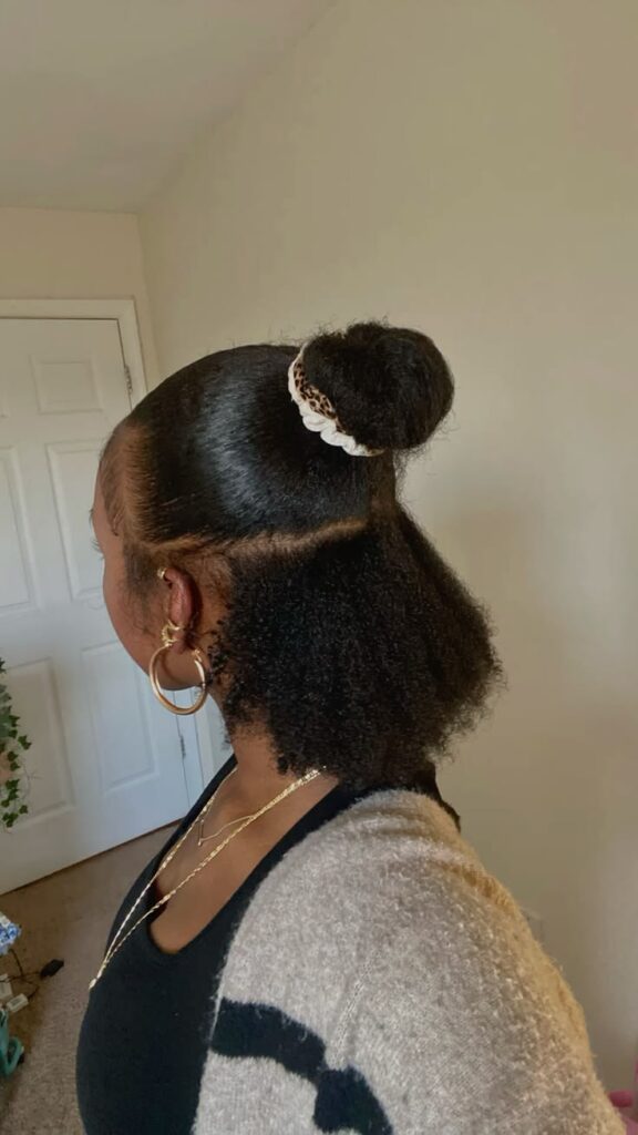 Half-up half-down bun hairstyle on natural 4C hair.