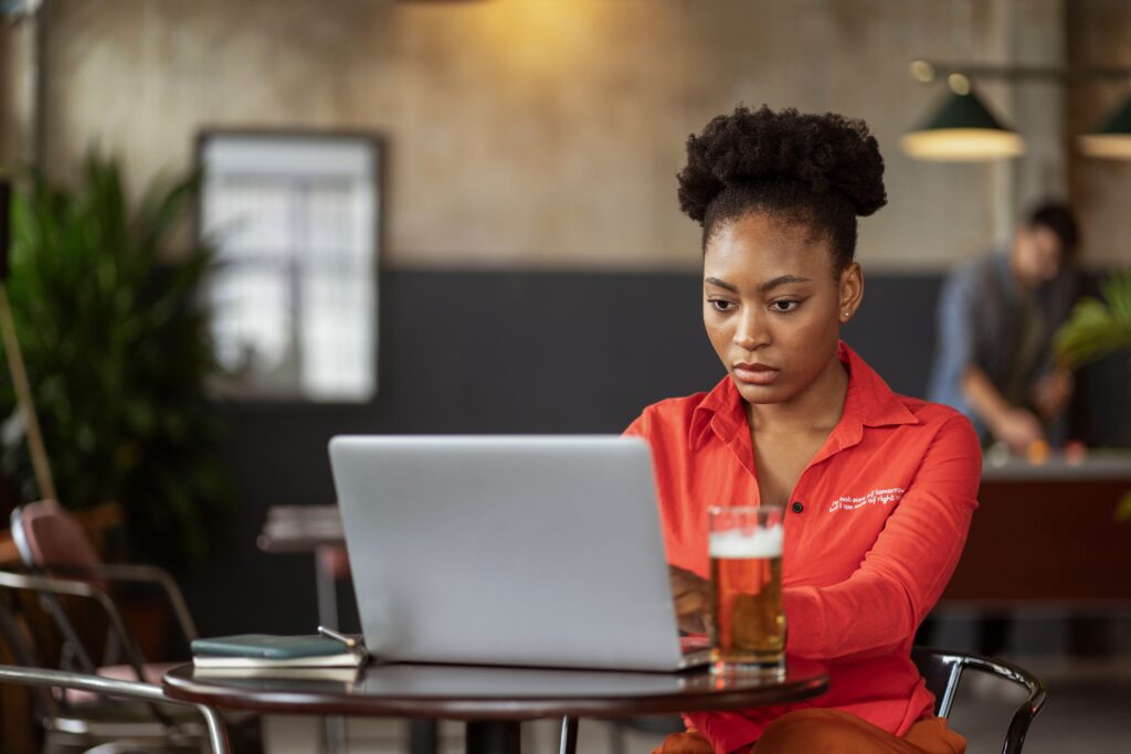 Woman wearing a neat low-manipulation puff hairstyle while working on her laptop.