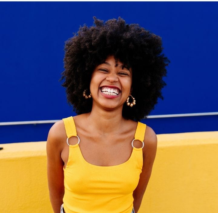 Woman confidently embracing her healthy natural 4C hair journey.