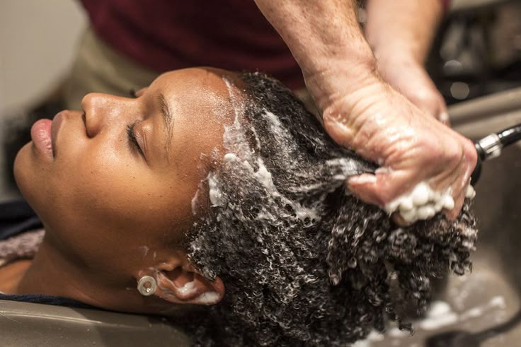 a woman washing healthy natural hair