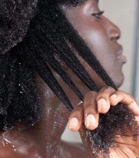 Black woman following a healthy wash day routine for natural 4C hair.