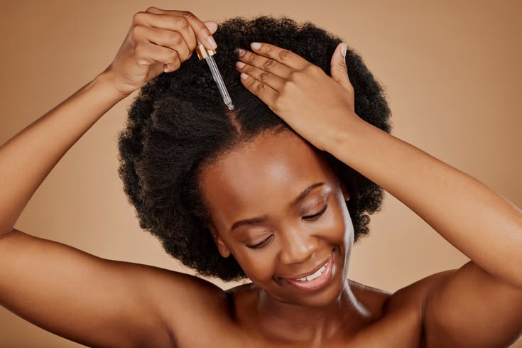 Woman oiling her hair after moisturizing.