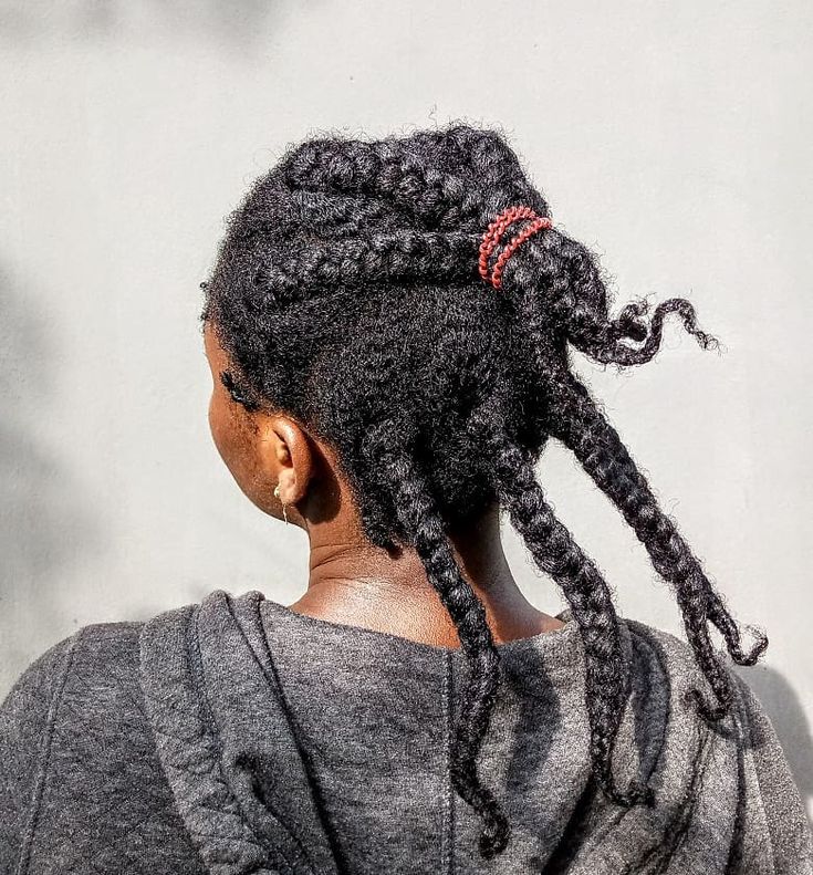 Woman with overgrown box braids showing visible new growth on natural 4C hair.