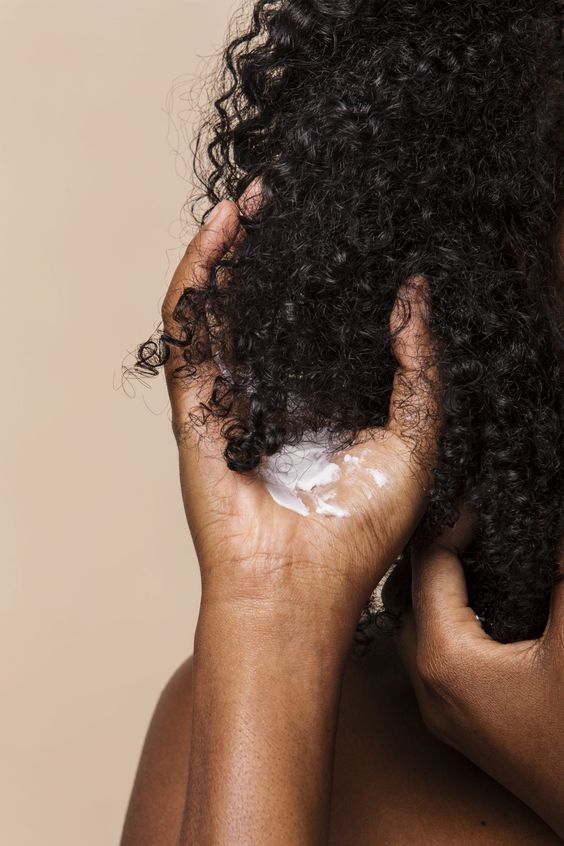 woman moisturizing her hair