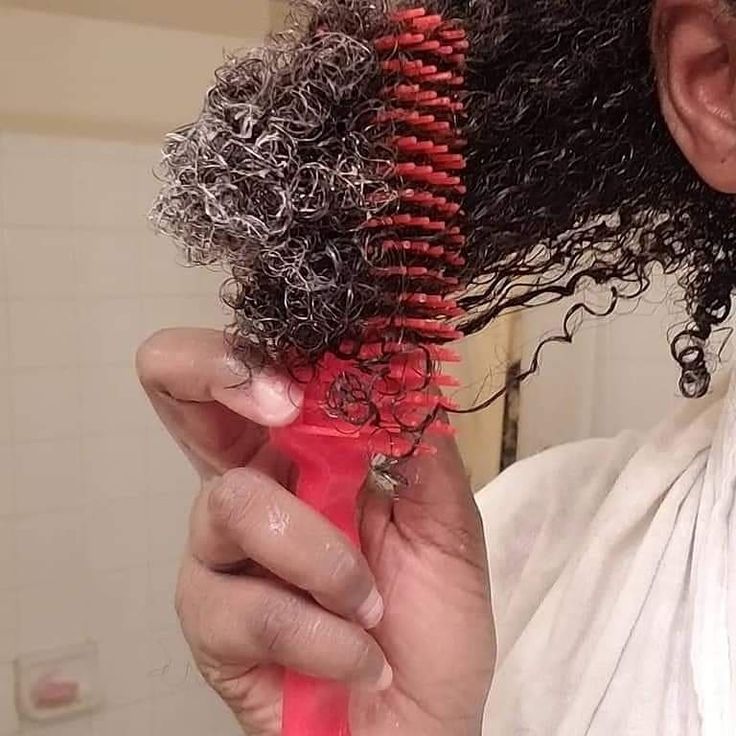 Black woman applying leave-in conditioner to the ends of her natural 4C hair