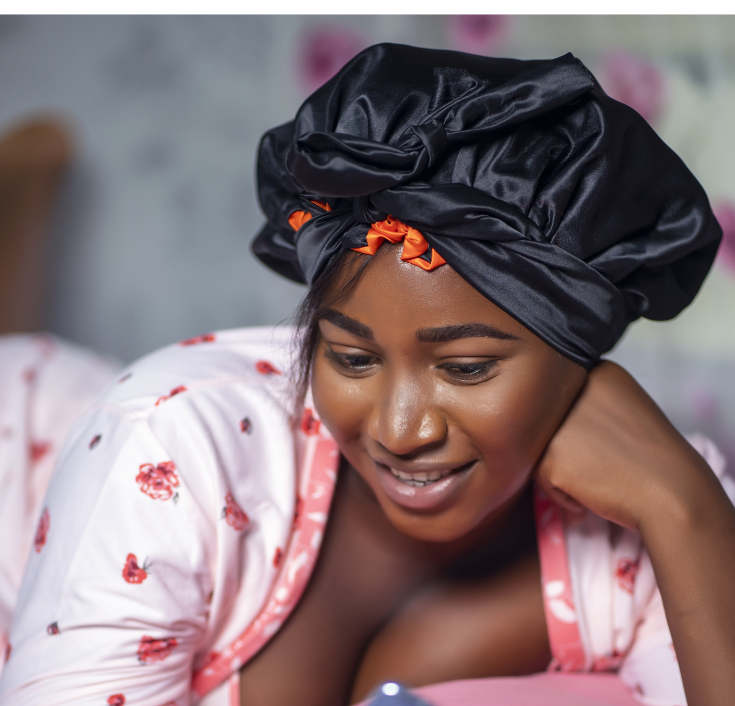 Woman putting on a satin bonnet before going to bed.