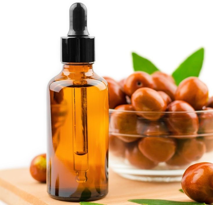 Bottle of pure jojoba oil with jojoba seeds