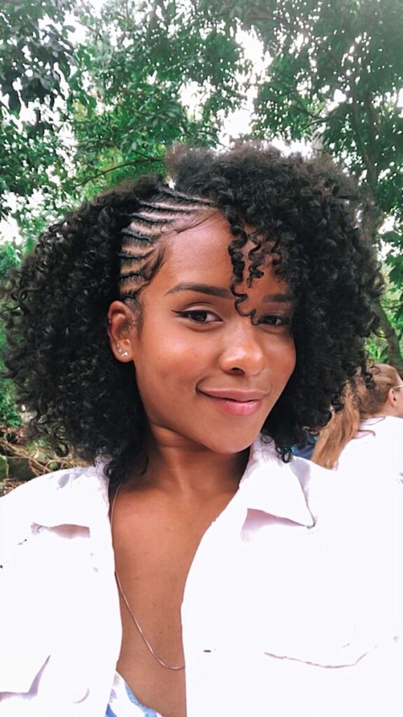 Side cornrows with loose curls on natural 4C hair.
