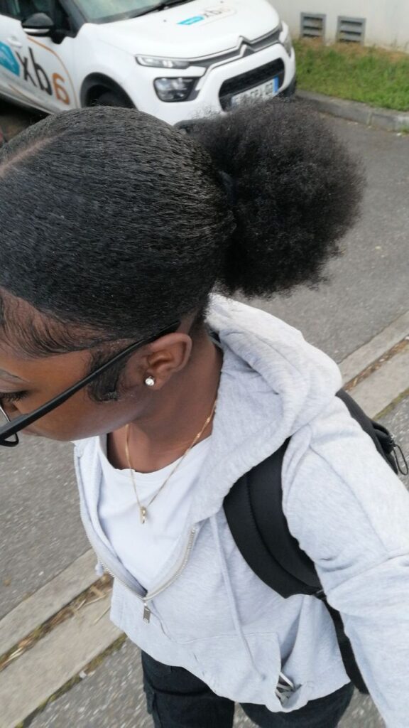 Sleek middle-part bun on natural 4C hair.