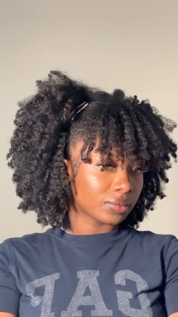 Natural 4C hairstyle with soft curly bangs.