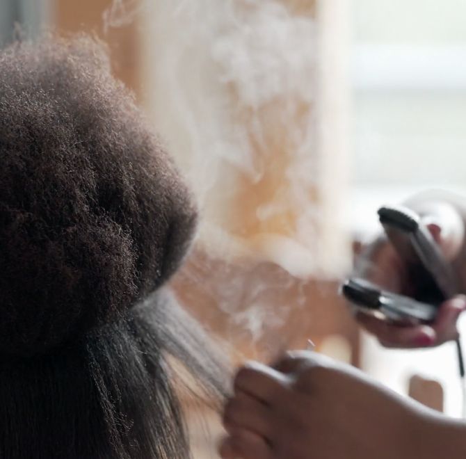 Woman applying heat on her hair
