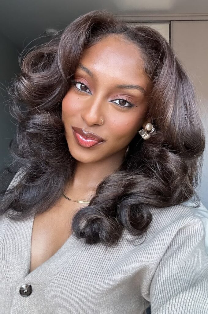 Protective wig worn over cornrows on natural hair.