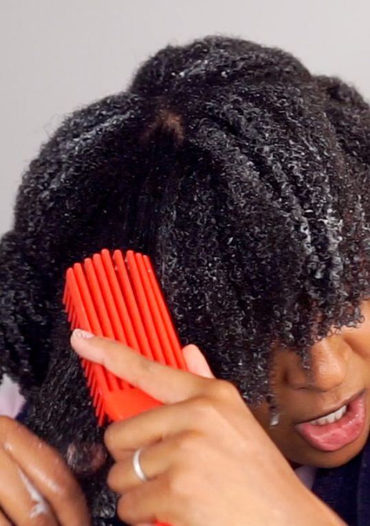 Woman clarifying and conditioning 4C natural hair