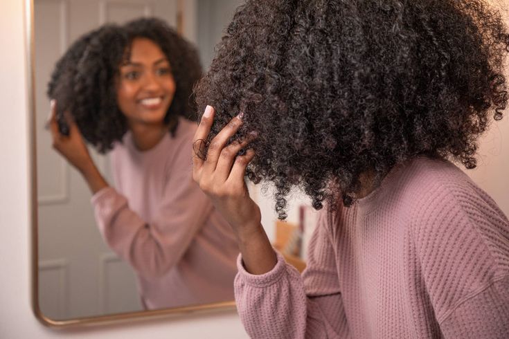Woman examining natural 4C hair