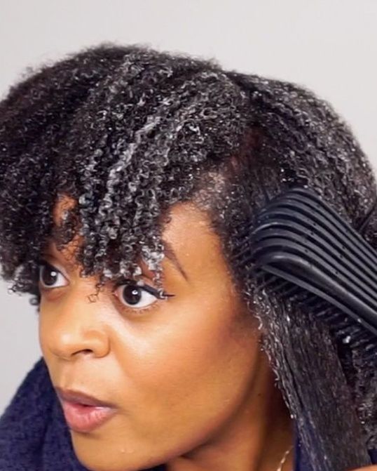 Black woman applying conditioner to sectioned natural 4C hair