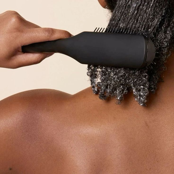 woman detangling hair while on hair mask