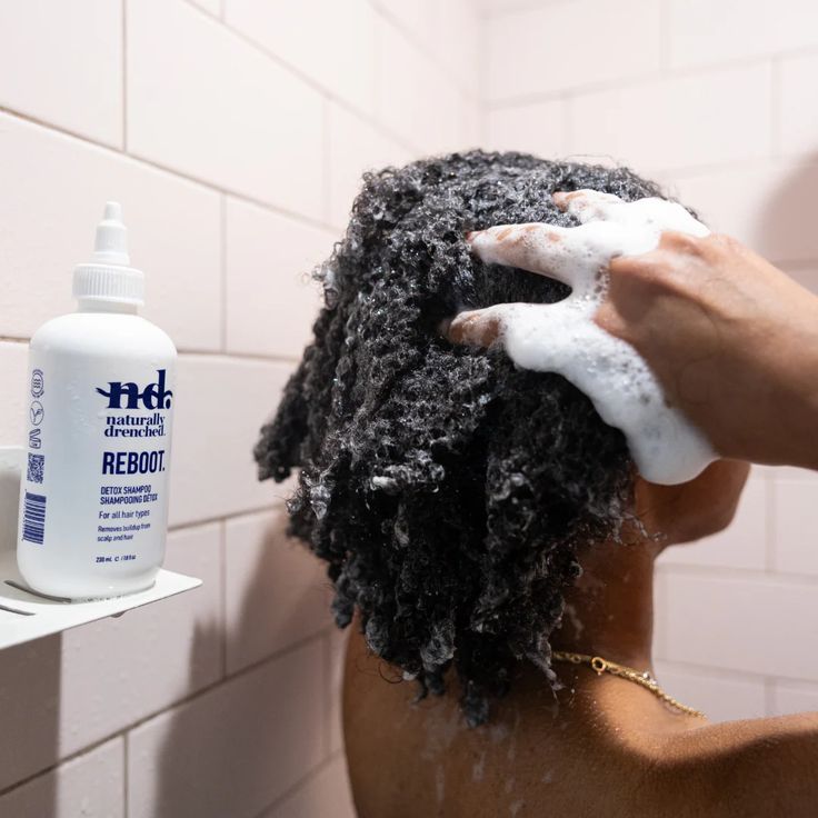 Black woman washing natural 4C hair with moisturizing shampoo