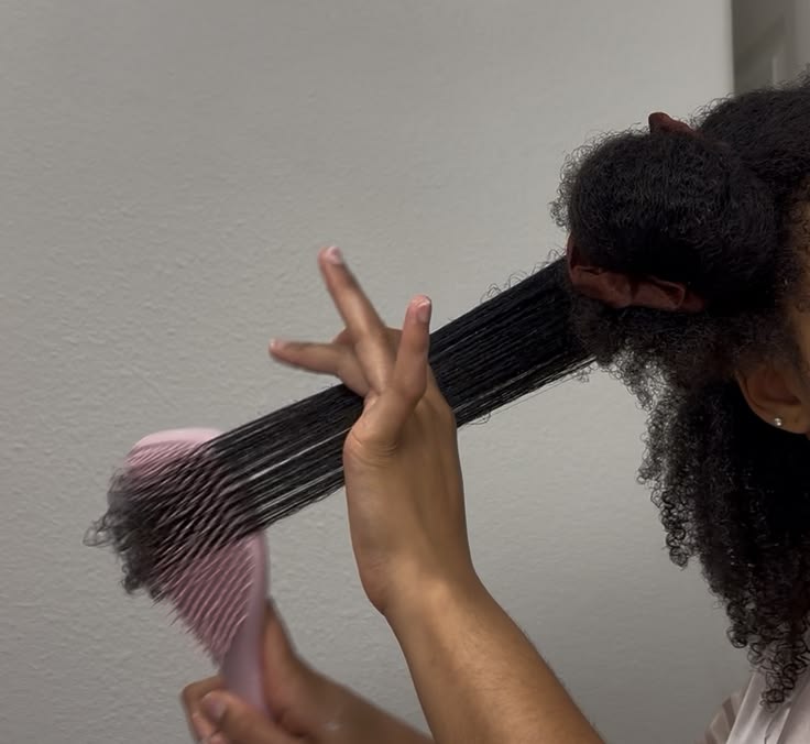 woman gently detangling her hair in sections