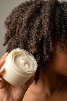 Soft, moisturized natural hair with a small jar of hair butter nearby.