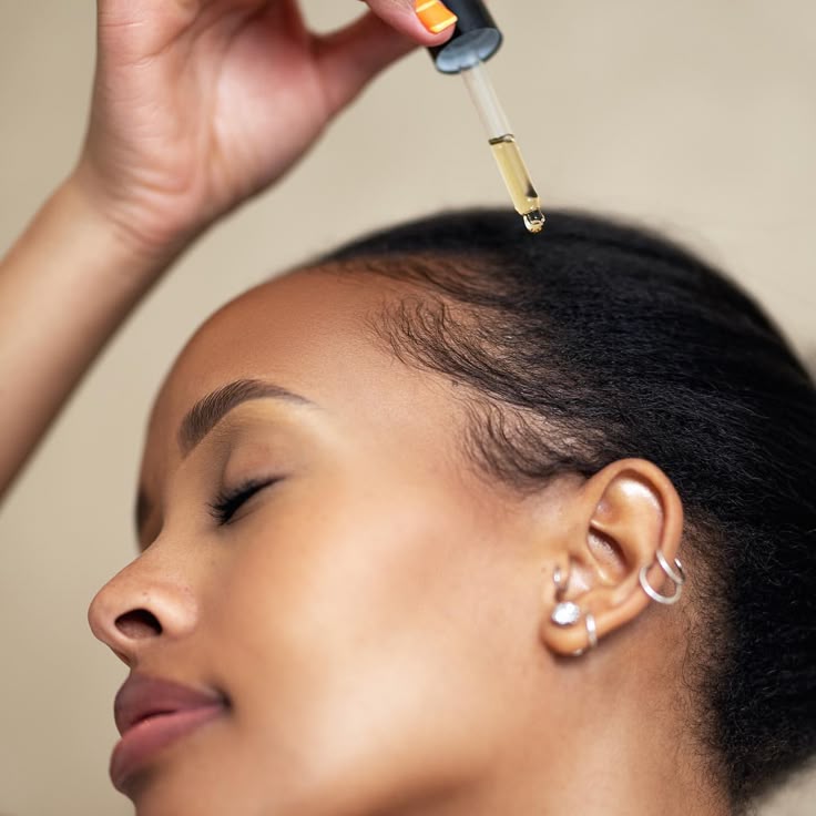 Black woman gently caring for natural hairline