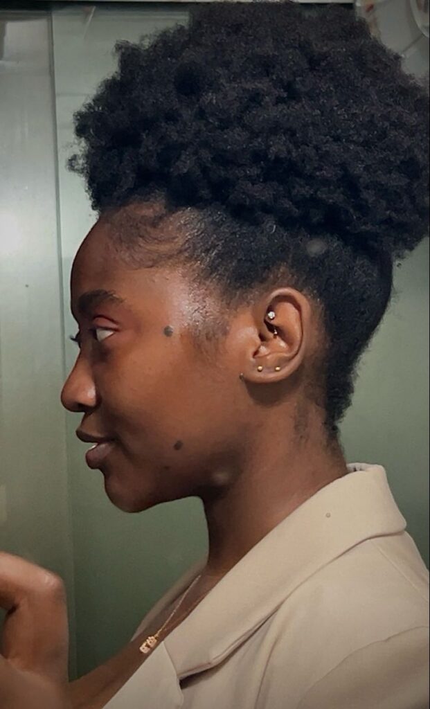 Black woman wearing a high afro puff on natural 4C hair