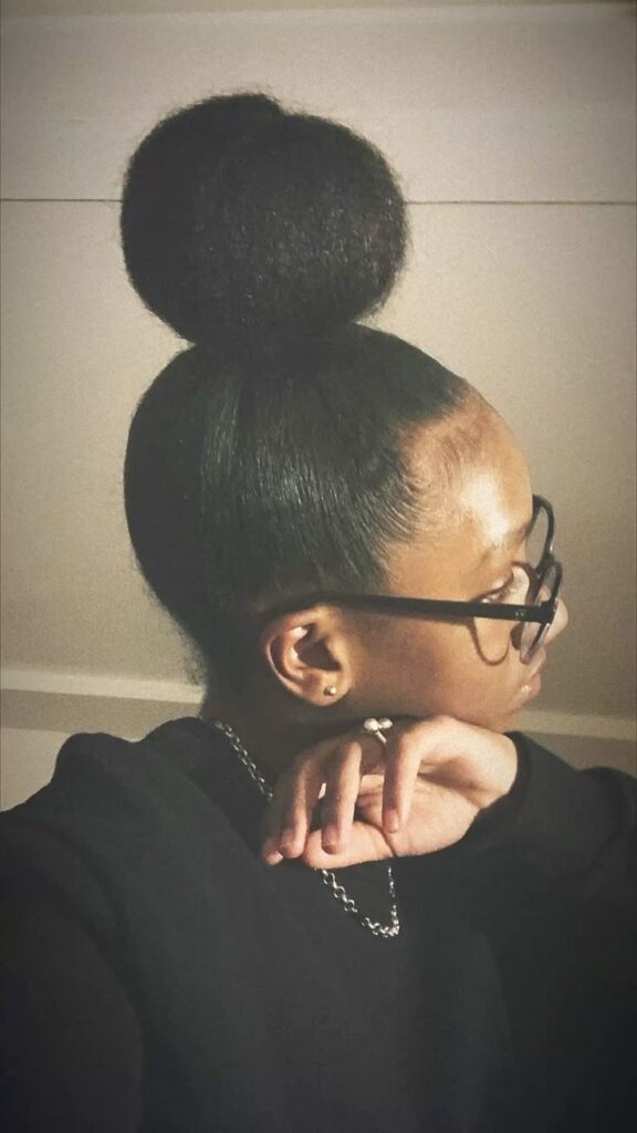 Natural 4C hair styled into a cute high bun