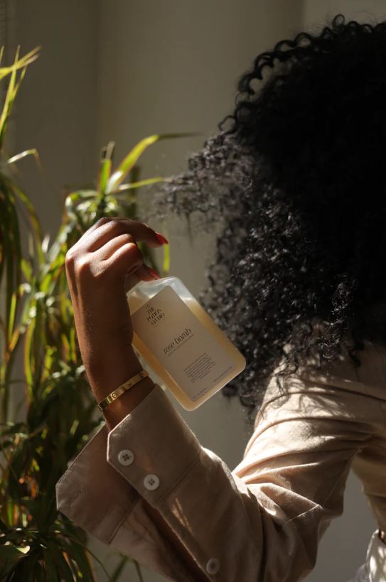 woman moisturizing her hair with leave-in conditioner