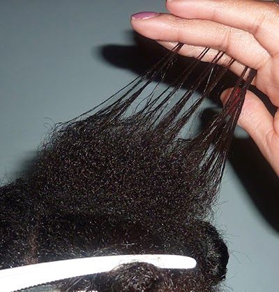 Close-up showing the line of demarcation between relaxed hair and natural 4C new growth.