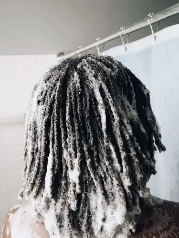 a woman washing her locs