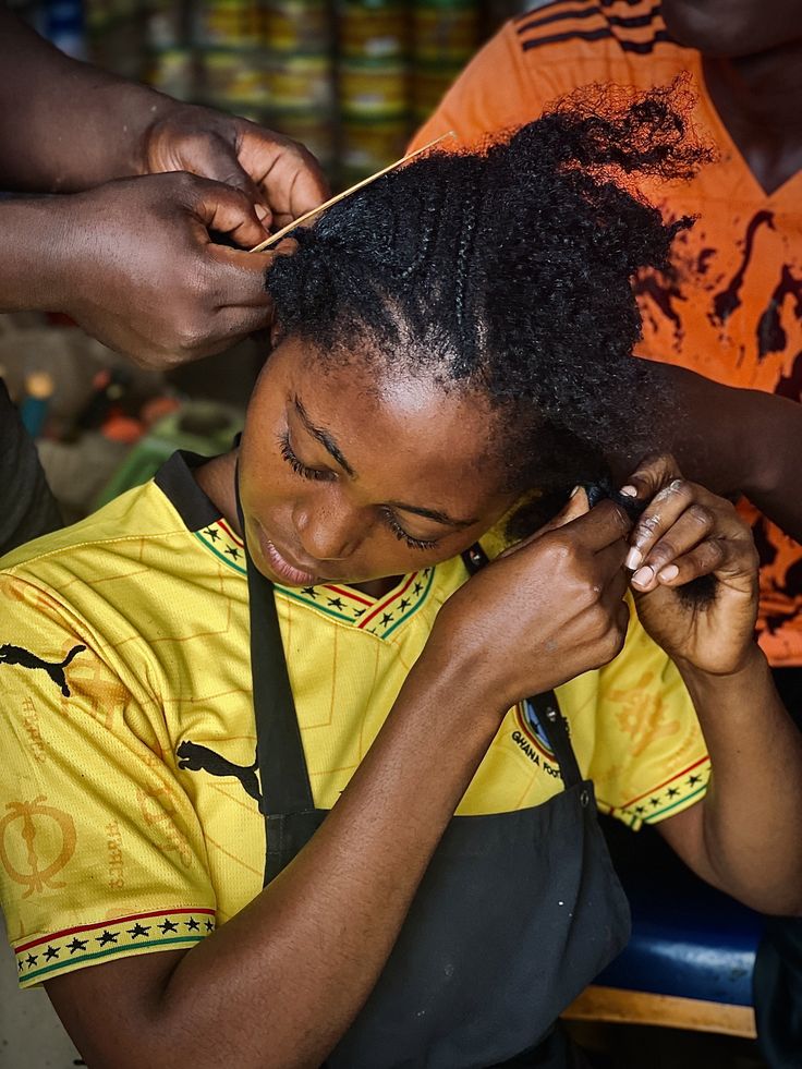  woman removing old braids to reveal natural 4C hair underneath