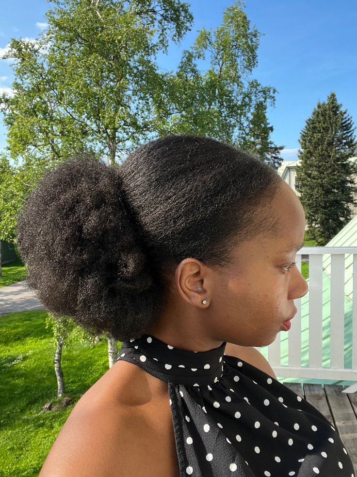 A Black woman wearing a low afro puff on natural 4C hair