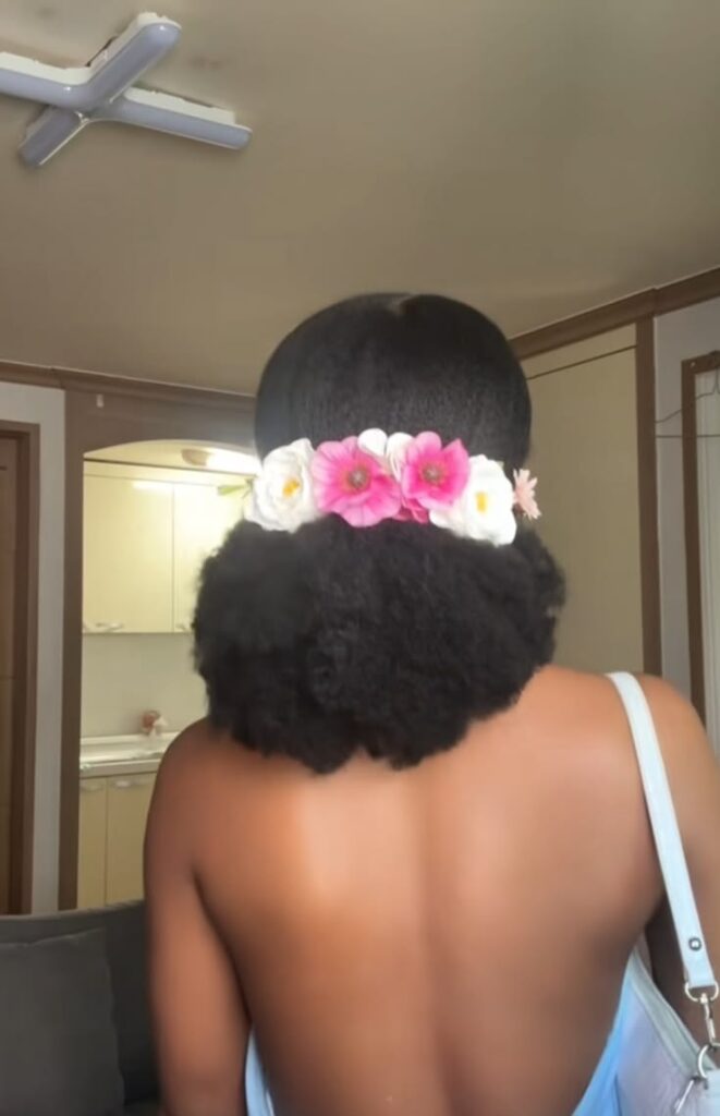 Low afro puff with floral crown on natural 4C hair