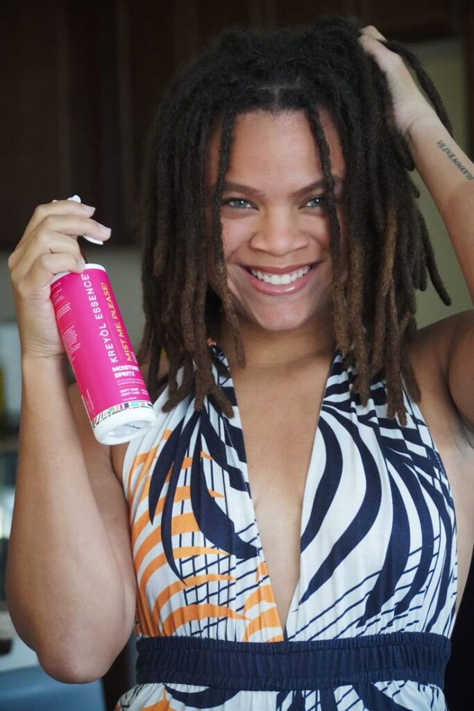 woman moisturizing her locs